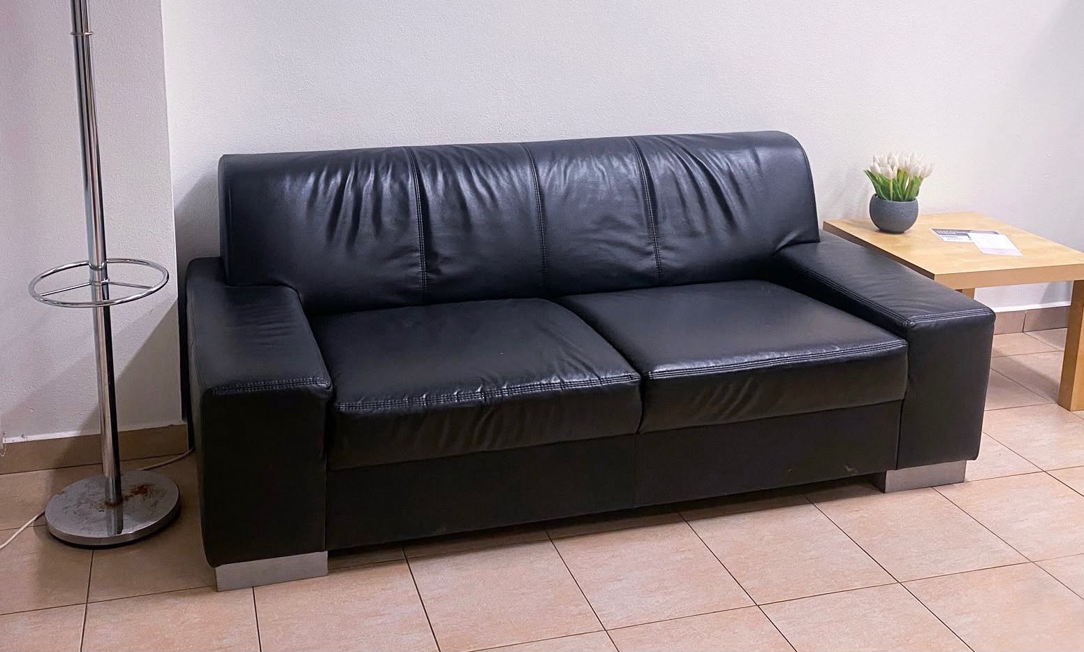 Černý kožený gauč v čekárně, kde si počkáte na masáž